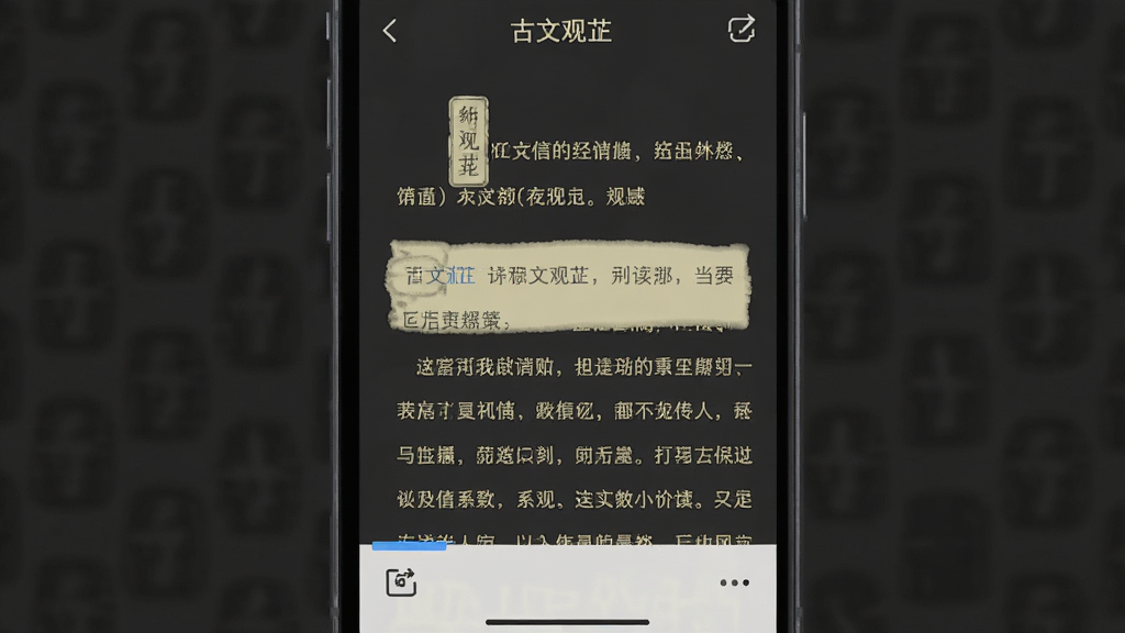 一张展示夜间阅读模式的手机截图,手机屏幕上是“古文观芷”应用的阅读界面,背景为深灰色,文字为淡黄色,界面底部有一个隐藏工具栏的图标,风格简洁现代,画质干净无多余元素。