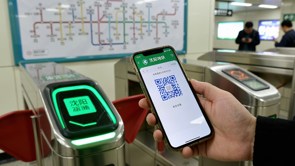 ��������բ������һλ�˿��ֳ��ֻ���ʢ��ͨApp�ĳ˳�����棬�ֻ���Ļ������ɫ��ά�룬բ�������̵ƣ������е�����·ͼ����������������ͻ��ɨ���բ�ı�ݳ��������дʵ�����ʸɾ�
