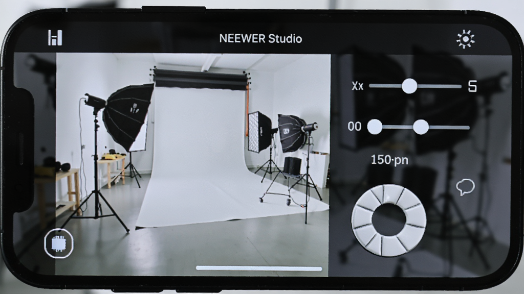 �������ֻ���ĻչʾNEEWER Studioң�ؽ��棬���������Ϸ�Ϊʵʱȡ�����棬���·�Ϊ�޴�İ�ɫ���Ű�ť��������ڻ��飻�Ű����࣬���Ϊ�����ͼ���ϸ��ģ�������ľ���Ԥ��Ч������Ƭ������һ�������Ĺ����ң����ʸɾ����޶���Ԫ��