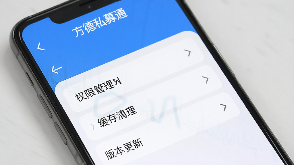 一张展示方德私募通应用设置页面的图片,手机屏幕显示权限管理、缓存清理、版本更新等选项,界面简洁,蓝白配色,屏幕上方有“方德私募通”应用名称,整体风格干净清爽,画质清晰