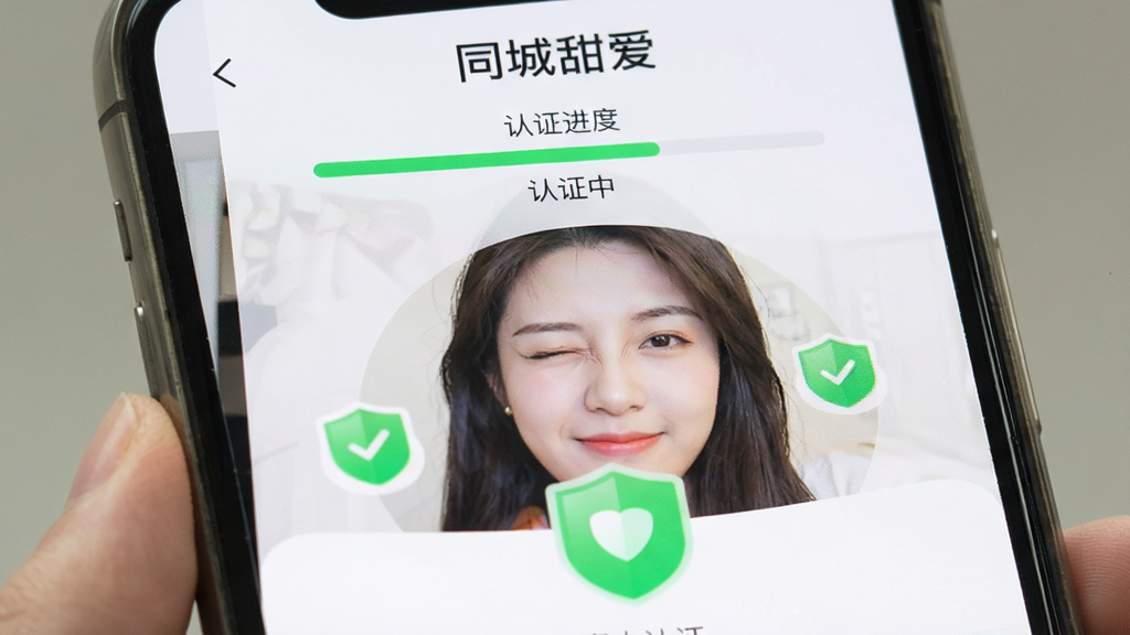 �ֻ���Ļ��д����������ʾ��ͬ���𰮡�App��������֤ҳ�棬һ���û������ž�ͷ��գ�۶��������涥���С�ͬ���𰮡���������֤��������ʾ����֤�С�����Χ����ɫ�İ�ȫ����ͼ�꣬��������죬���ʸɾ�