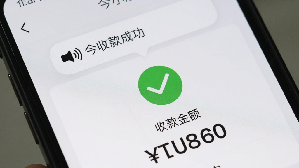 一张手机屏幕特写图,画面中显示今小店的收款成功页面,绿色对勾图标醒目,下方显示收款金额数字,手机顶部弹出语音播报的气泡提示,背景是简洁的浅色界面,风格真实自然,画质干净无多余元素