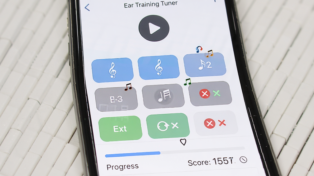һ��Ear Training Tuner������ϰ�����ͼƬ������Ϊ�ֻ���Ļ��ʾ����ѡ����棬�����Ϸ��ǲ��Ű�ť���м�������ѡ�ť�����·��ǽ��Ⱥ͵÷���ʾ��������¼�Լ��ϸ�ڰ���������������Ч������ȷ������ͼ�꣬���ʸ���ɾ��޶���Ԫ��