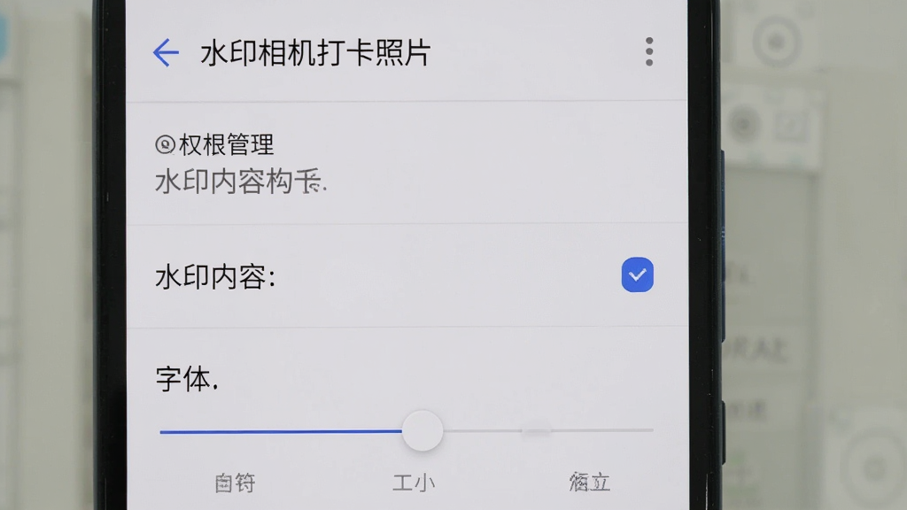 一部安卓手机显示“水印相机打卡照片”的设置页面,画面中可以看到权限管理、水印内容勾选、字体大小调节等选项,界面设计简洁,文字清晰,背景为浅色,整体画质干净,无多余装饰元素