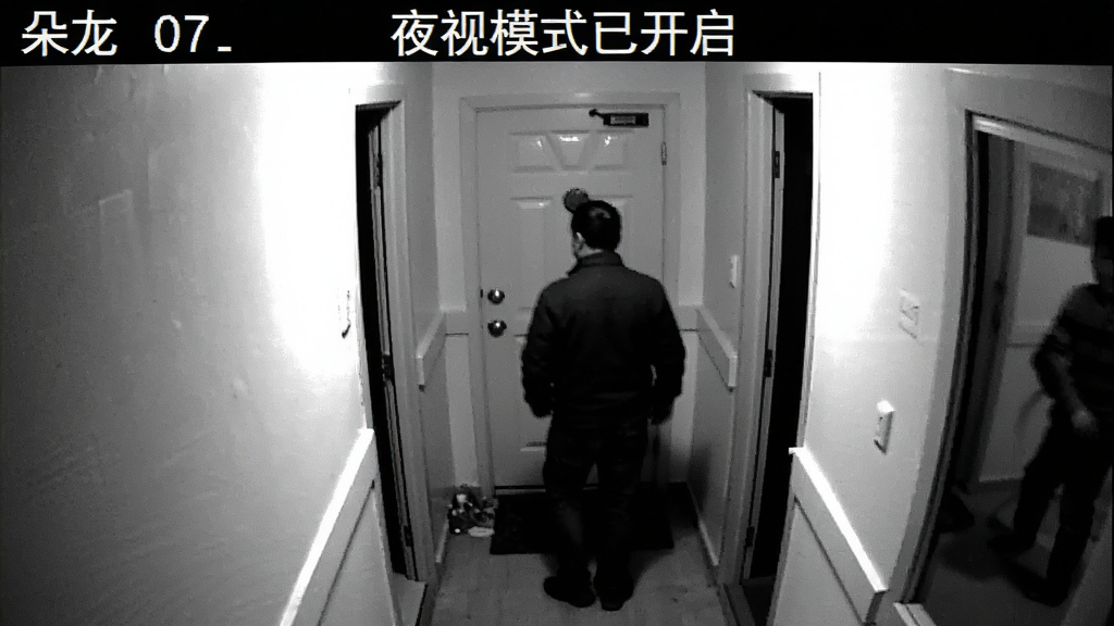 朵尔监护 夜间监控画面 黑白红外模式 显示门口走廊 能看清有人经过的轮廓 画面噪点控制良好 顶部显示夜视模式已开启 界面简洁 画质干净