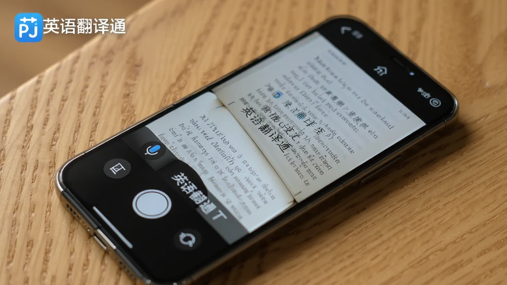 一部手机放在桌面上,屏幕显示英语翻译通APP的拍照翻译界面,摄像头正对着一本英文书籍的页面,屏幕上叠加了中文翻译结果,旁边有语音翻译和文本翻译的图标按钮,背景是木质桌面,光线柔和,风格写实,画质干净,画面中带有“英语翻译通”文字标识