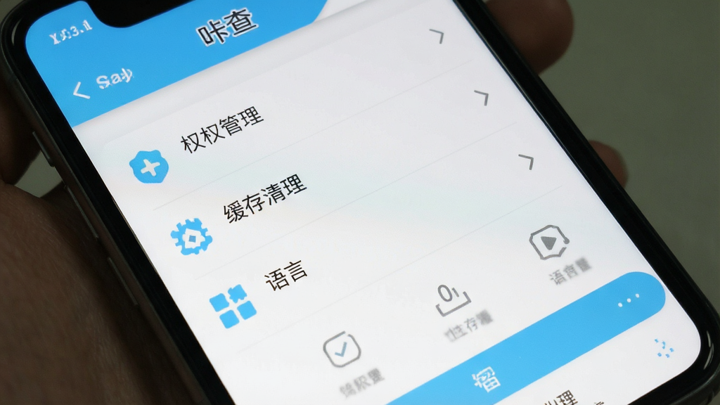 一张手机屏幕截图,展示“咔查”的设置页面,里面有权限管理、缓存清理、语言选择等选项,界面以白色和浅蓝色为主,图标简洁,布局清晰,画质干净