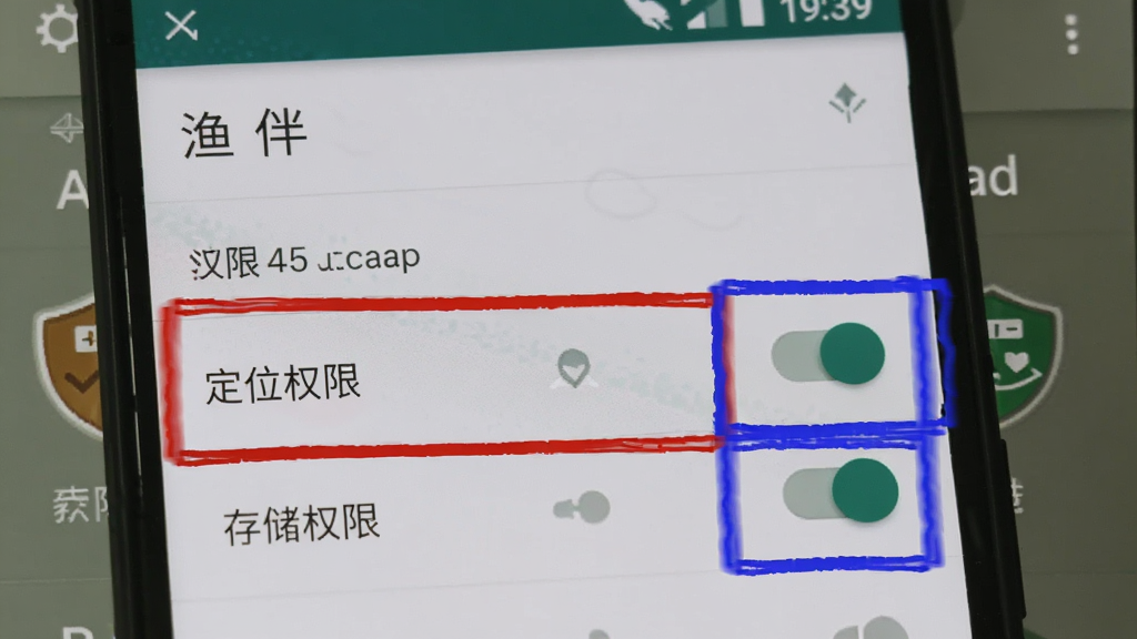 手机屏幕展示“渔伴”App的权限设置页面,高亮显示“定位权限”和“存储权限”开关,旁边有红蓝色标注框,背景为安卓系统设置界面风格,简洁清晰,画质干净