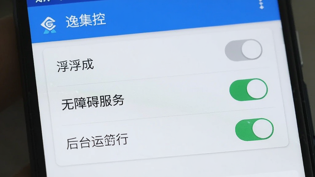 一部安卓手机屏幕上显示“逸集控”的权限设置页面,页面中有悬浮窗、无障碍服务、后台运行三个开关选项,其中悬浮窗和无障碍服务开关处于开启状态,界面风格简洁,色调蓝白,画质干净,无多余元素