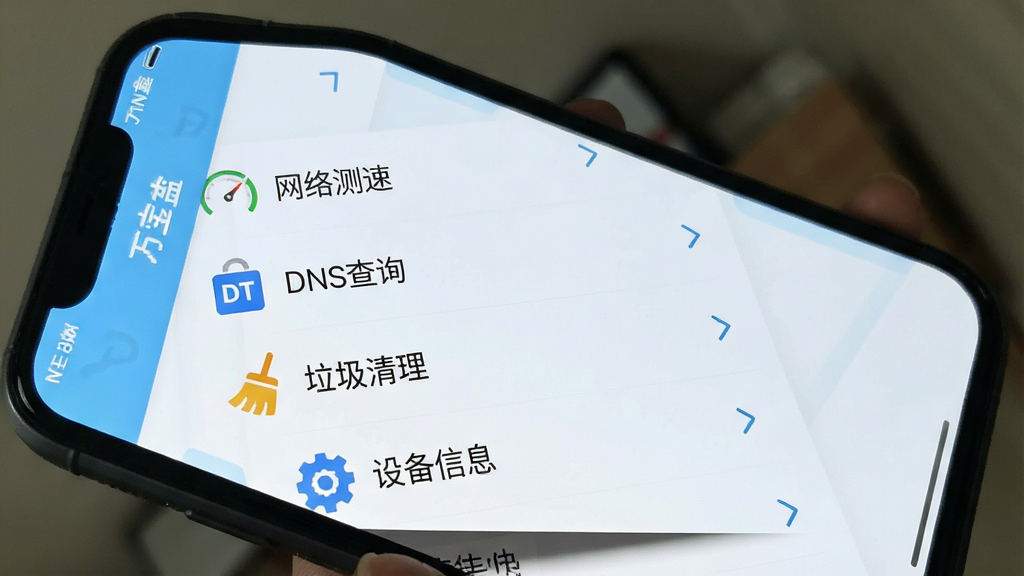 一张手机屏幕截图风格的详细图片,画面展示“万宝盒”应用内部的工具列表页面,背景为淡蓝色,列表中包含“网络测速”、“DNS查询”、“垃圾清理”、“设备信息”等选项,每个选项左侧有对应的简约图标,右侧有进入箭头,整体排版整齐,风格简洁明快,画质干净无多余元素